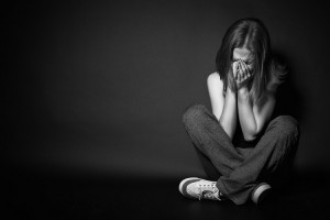 sad woman in depression and despair crying on black dark background