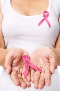 Woman showing pink ribbon to support breast cancer cause. PS : you can change the ribbon color to red to support AIDS cause