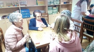 Voluntaria de FISC Joven jugando a las cartas con un grupo de ancianas de la residencia